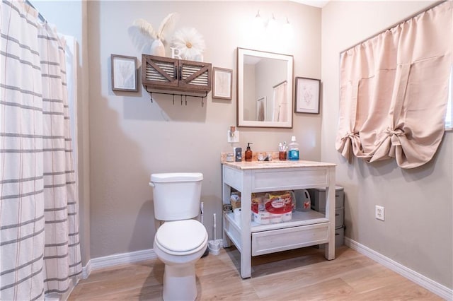 bathroom featuring a shower with curtain, wood-type flooring, and toilet