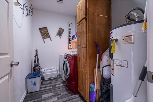 laundry area with cabinets, washer and dryer, dark wood-type flooring, and water heater