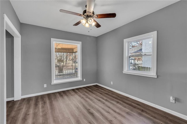 spare room with a wealth of natural light, hardwood / wood-style floors, and ceiling fan