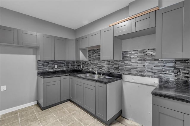 kitchen with gray cabinets, decorative backsplash, sink, and light tile patterned floors