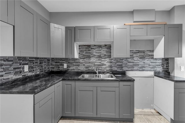 kitchen with gray cabinets, sink, and tasteful backsplash