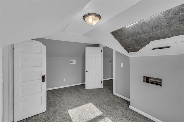 additional living space with lofted ceiling and dark colored carpet