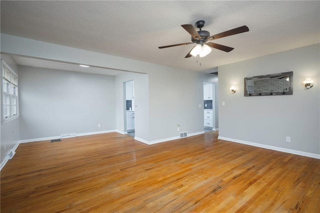 unfurnished room featuring a textured ceiling, ceiling fan, and light hardwood / wood-style flooring