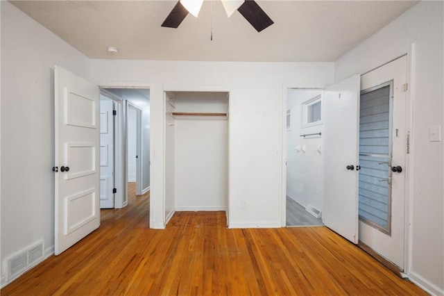 unfurnished bedroom featuring ceiling fan, a textured ceiling, and light hardwood / wood-style floors