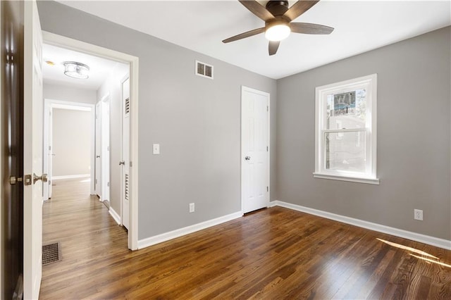 unfurnished room with dark hardwood / wood-style floors and ceiling fan