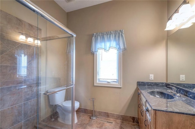 bathroom with vanity, toilet, an enclosed shower, and tile patterned flooring