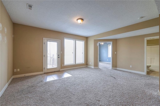 carpeted spare room featuring a textured ceiling