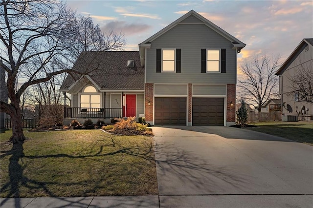 traditional home with driveway, a yard, fence, and brick siding