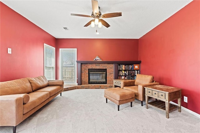 living room featuring carpet floors, a fireplace, visible vents, a ceiling fan, and baseboards