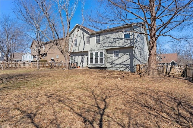 rear view of house featuring a yard, a fenced backyard, and a residential view