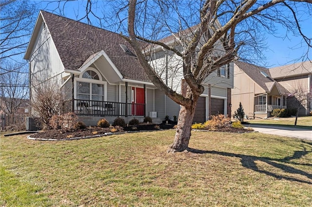 view of front of property with concrete driveway, roof with shingles, an attached garage, and a front lawn