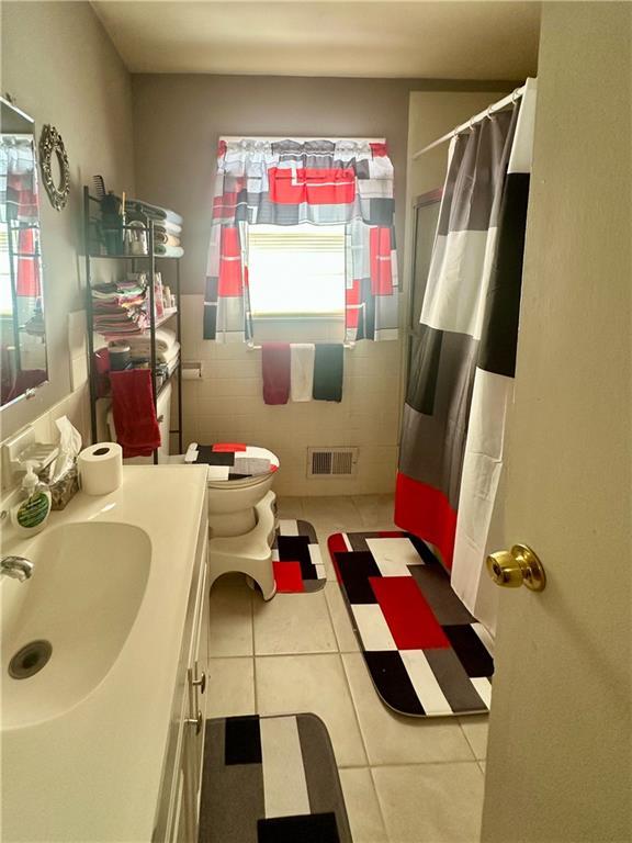 bathroom with vanity, a shower with curtain, tile patterned floors, and toilet