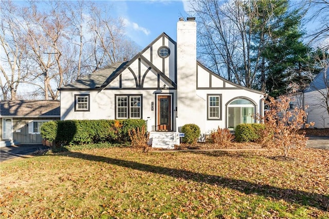 english style home featuring a front yard