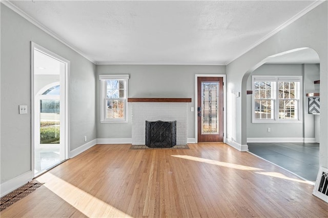 unfurnished living room featuring a fireplace, light hardwood / wood-style flooring, and a wealth of natural light