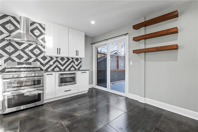 kitchen with island exhaust hood, decorative backsplash, white cabinets, and appliances with stainless steel finishes