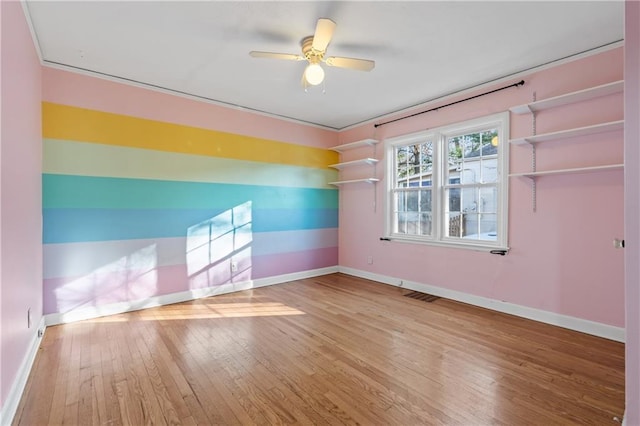 empty room with hardwood / wood-style flooring and ceiling fan