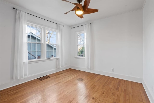 empty room with light wood-type flooring, a wealth of natural light, and ceiling fan