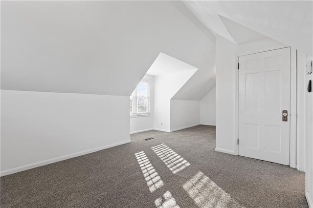 additional living space featuring carpet flooring and lofted ceiling