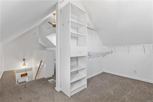 walk in closet with carpet flooring, ceiling fan, and vaulted ceiling