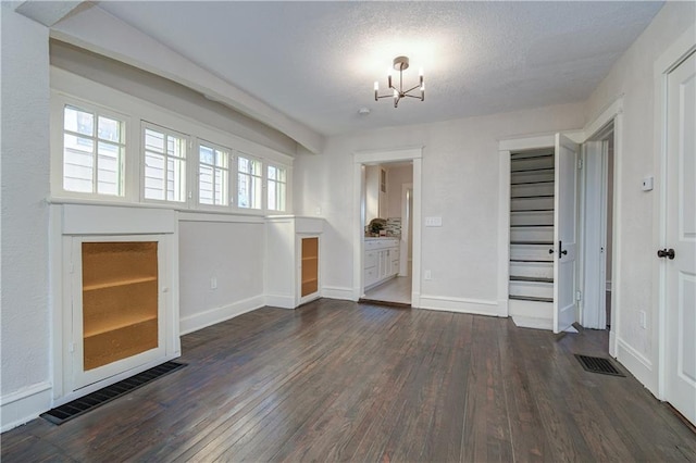 interior space featuring dark hardwood / wood-style floors, a textured ceiling, and an inviting chandelier