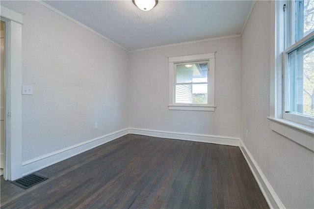 unfurnished room with a wealth of natural light, dark hardwood / wood-style floors, and ornamental molding