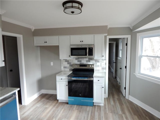 kitchen featuring backsplash, white cabinetry, stainless steel appliances, and light hardwood / wood-style floors