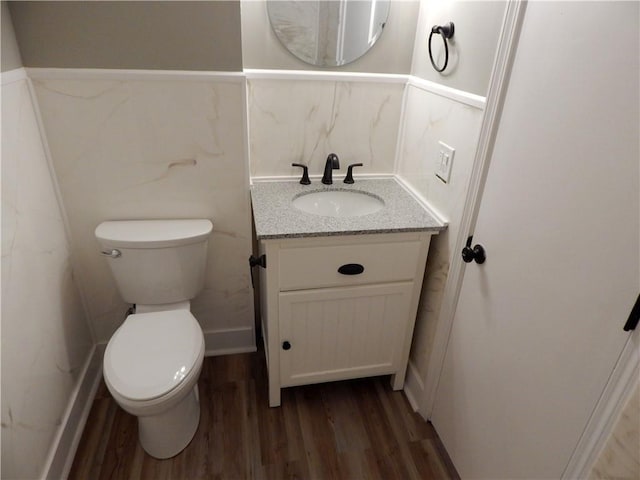 bathroom with hardwood / wood-style floors, vanity, and toilet