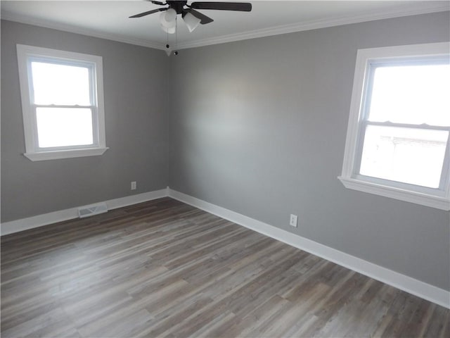 unfurnished room featuring a wealth of natural light, crown molding, ceiling fan, and wood-type flooring