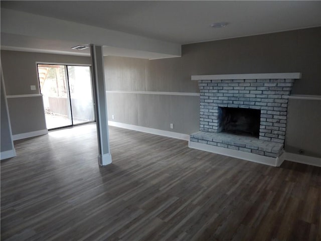 unfurnished living room featuring a fireplace and dark wood-type flooring