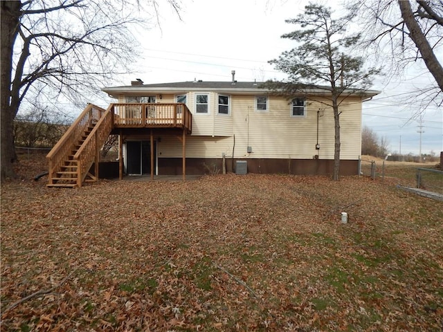 rear view of property featuring cooling unit and a wooden deck