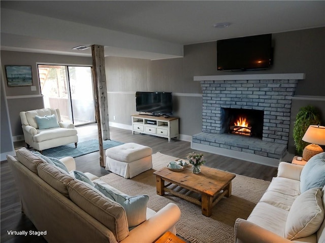 living room featuring hardwood / wood-style flooring and a brick fireplace