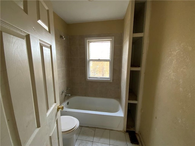 bathroom with tile patterned floors, toilet, and tiled shower / bath