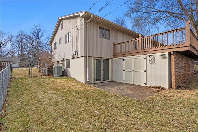 back of house with central AC, fence, a lawn, a wooden deck, and a gate