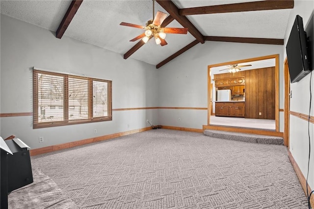 unfurnished room featuring a textured ceiling, carpet floors, baseboards, and vaulted ceiling with beams