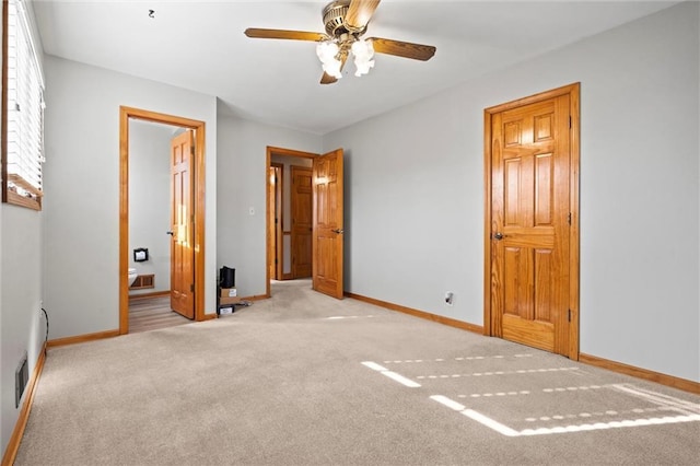 unfurnished bedroom with carpet, visible vents, ceiling fan, ensuite bath, and baseboards