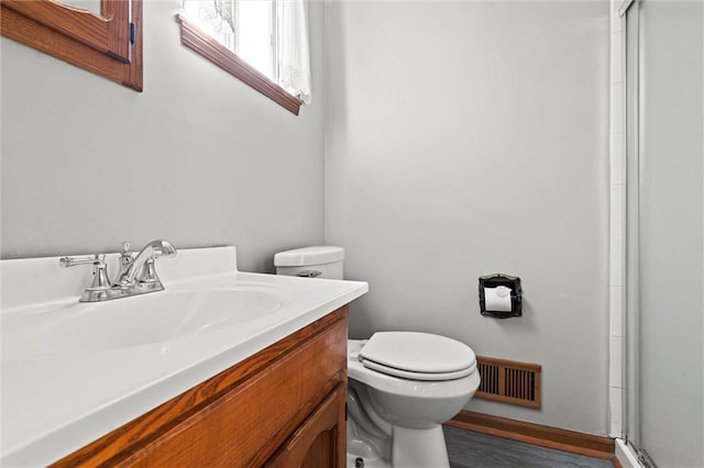 full bathroom with toilet, wood finished floors, vanity, visible vents, and an enclosed shower