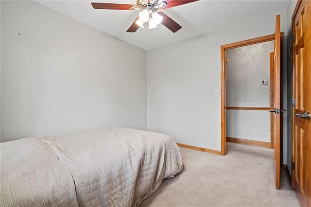 bedroom featuring light carpet, ceiling fan, and baseboards