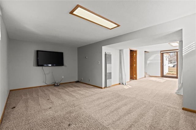 unfurnished living room with carpet and baseboards