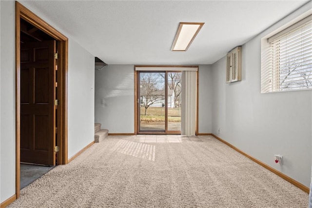 carpeted spare room featuring stairway and baseboards