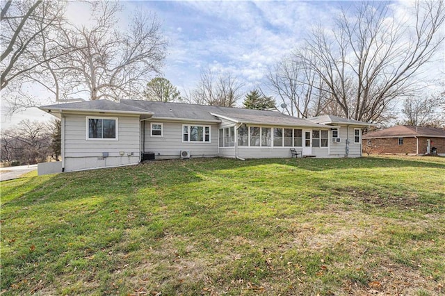 rear view of house featuring a lawn and a sunroom