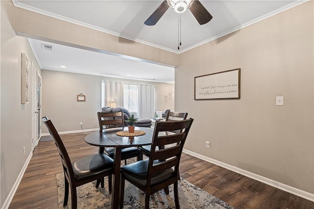 dining room featuring ornamental molding, dark wood-type flooring, and ceiling fan