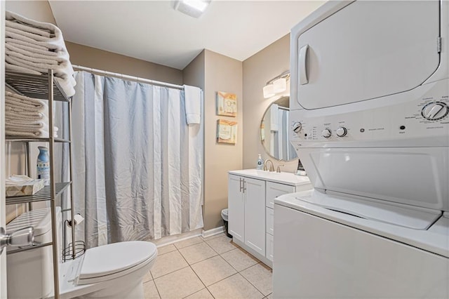 bathroom featuring walk in shower, toilet, vanity, stacked washer / dryer, and tile patterned flooring