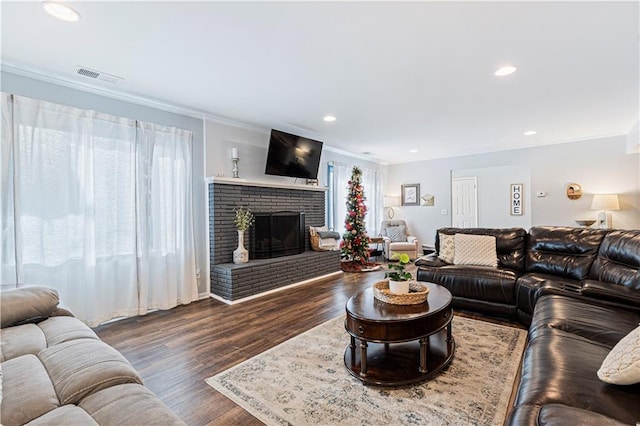 living room featuring a fireplace, ornamental molding, and dark hardwood / wood-style floors