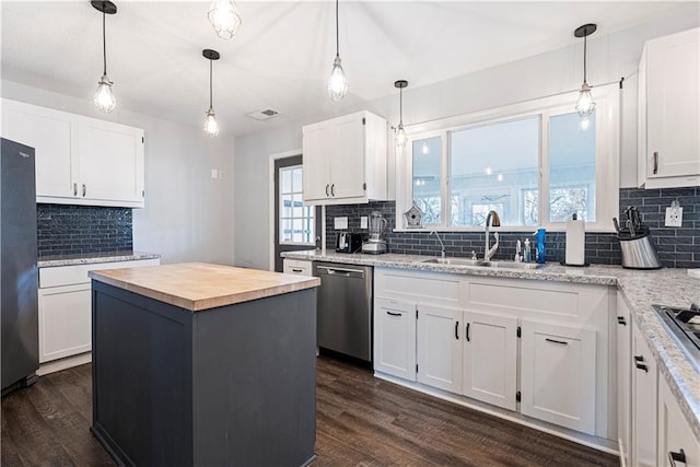 kitchen with sink, white cabinets, decorative backsplash, a center island, and stainless steel appliances