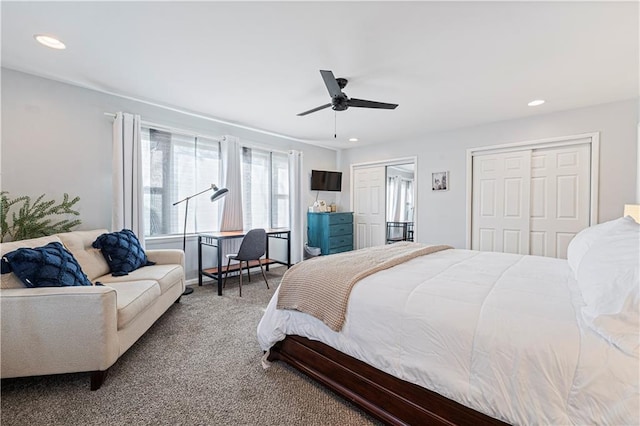 carpeted bedroom featuring multiple closets and ceiling fan