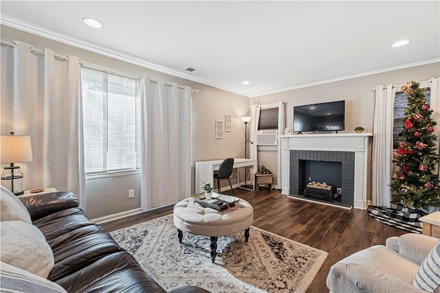 living room featuring crown molding, a brick fireplace, dark wood-type flooring, and a wealth of natural light