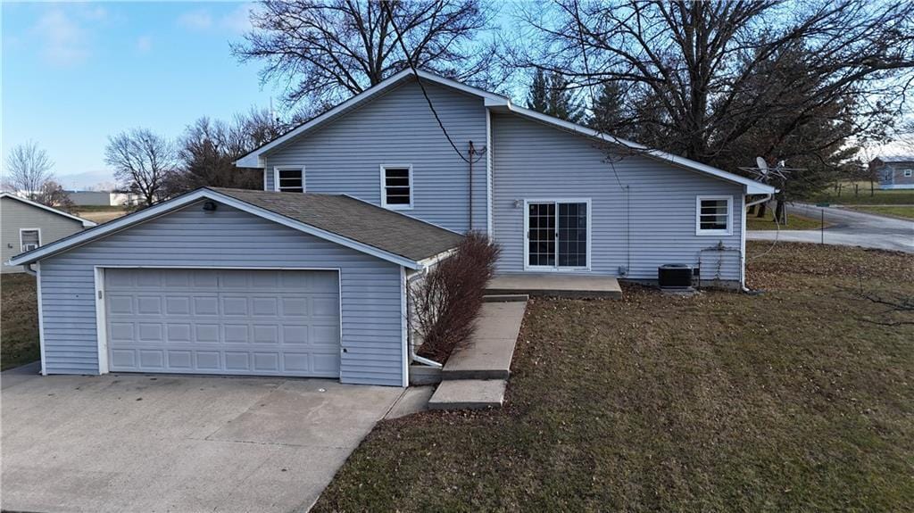 exterior space featuring a yard, cooling unit, and a garage