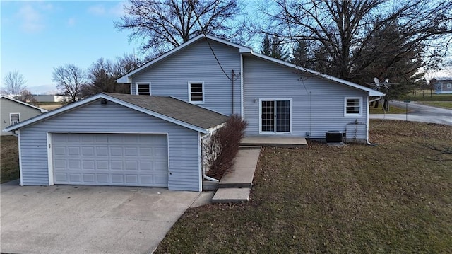 exterior space featuring a yard, cooling unit, and a garage