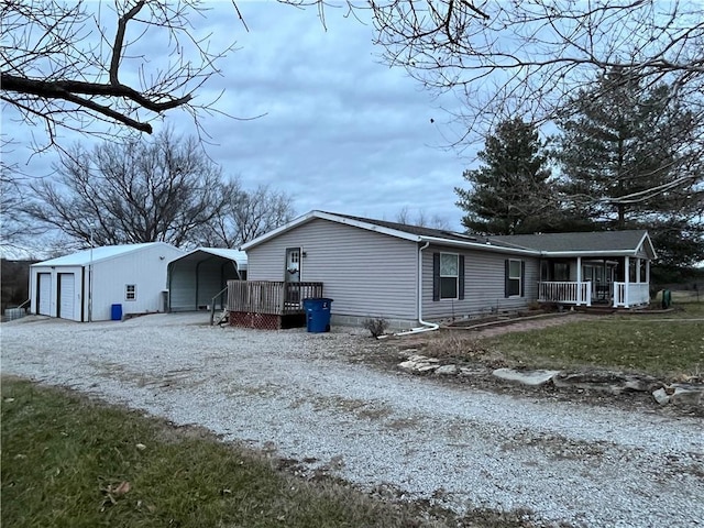 view of side of property featuring an outbuilding, a garage, a carport, and a sunroom