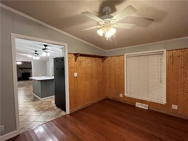 interior space featuring lofted ceiling, wood-type flooring, crown molding, and wooden walls